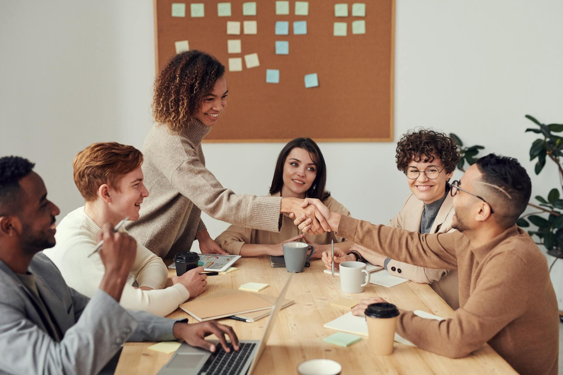 A woman shaking hands with a man during a meeting
