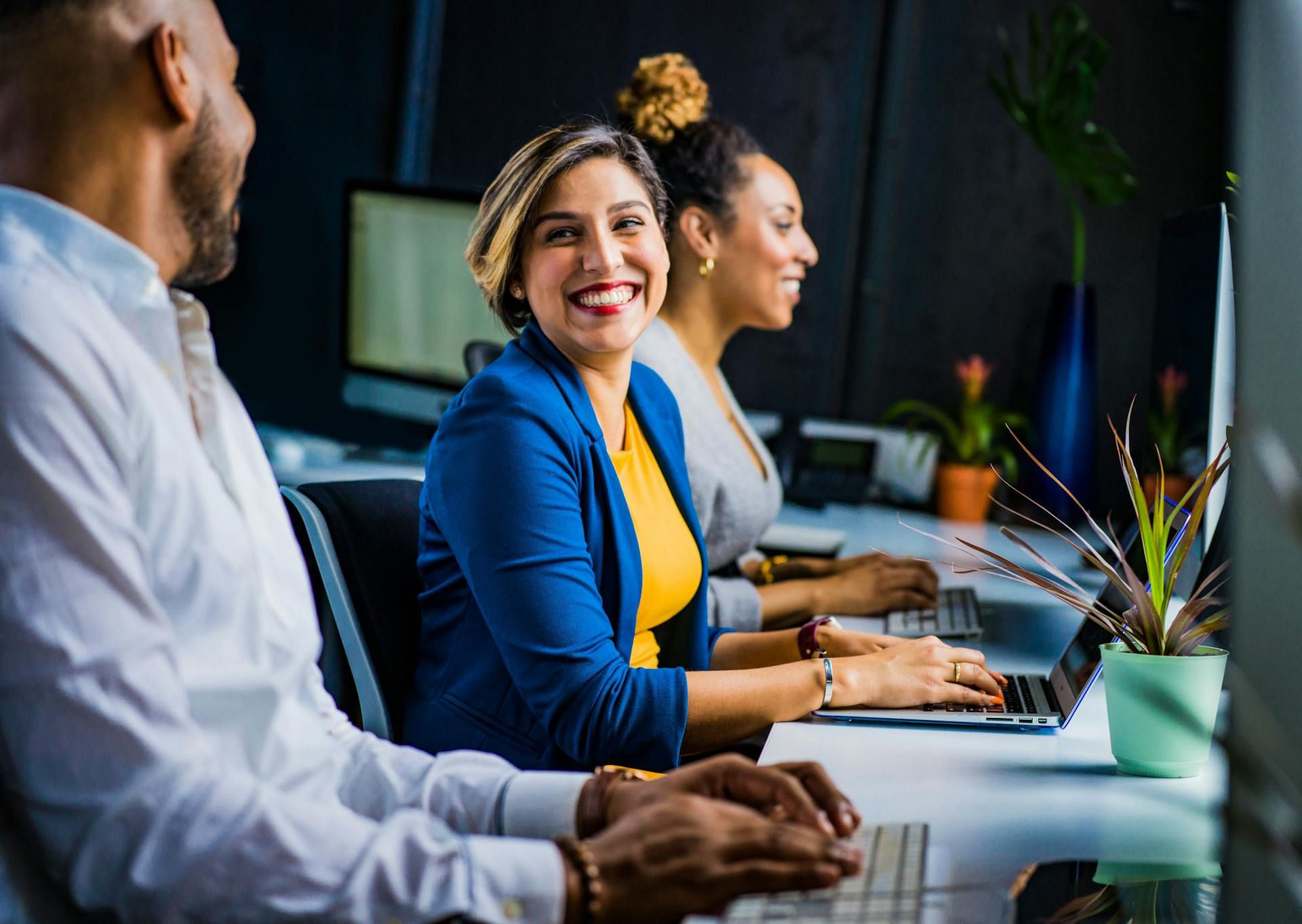 A woman smiling and talking to her coworkers