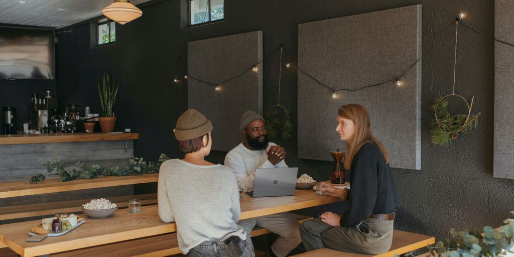 Three co-workers sitting together in the office with Surface laptop on the table