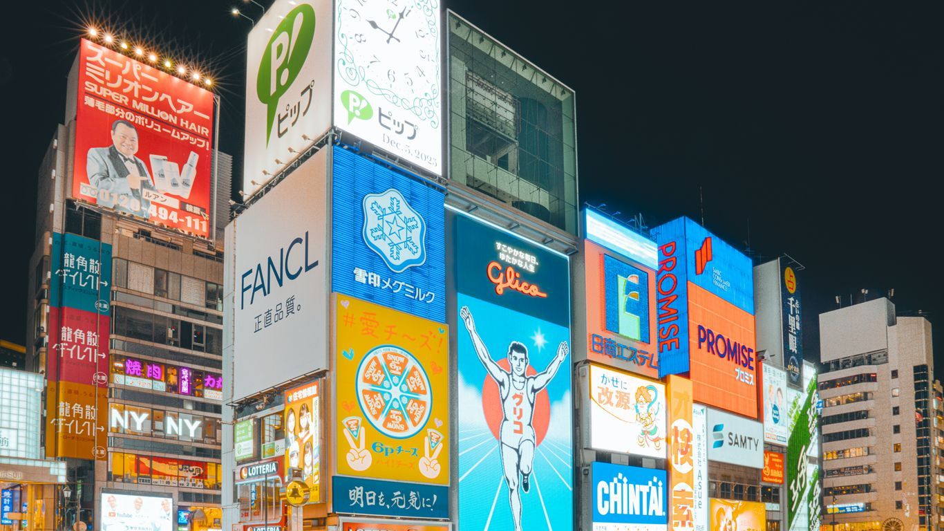 a large group of people walking around a city at night