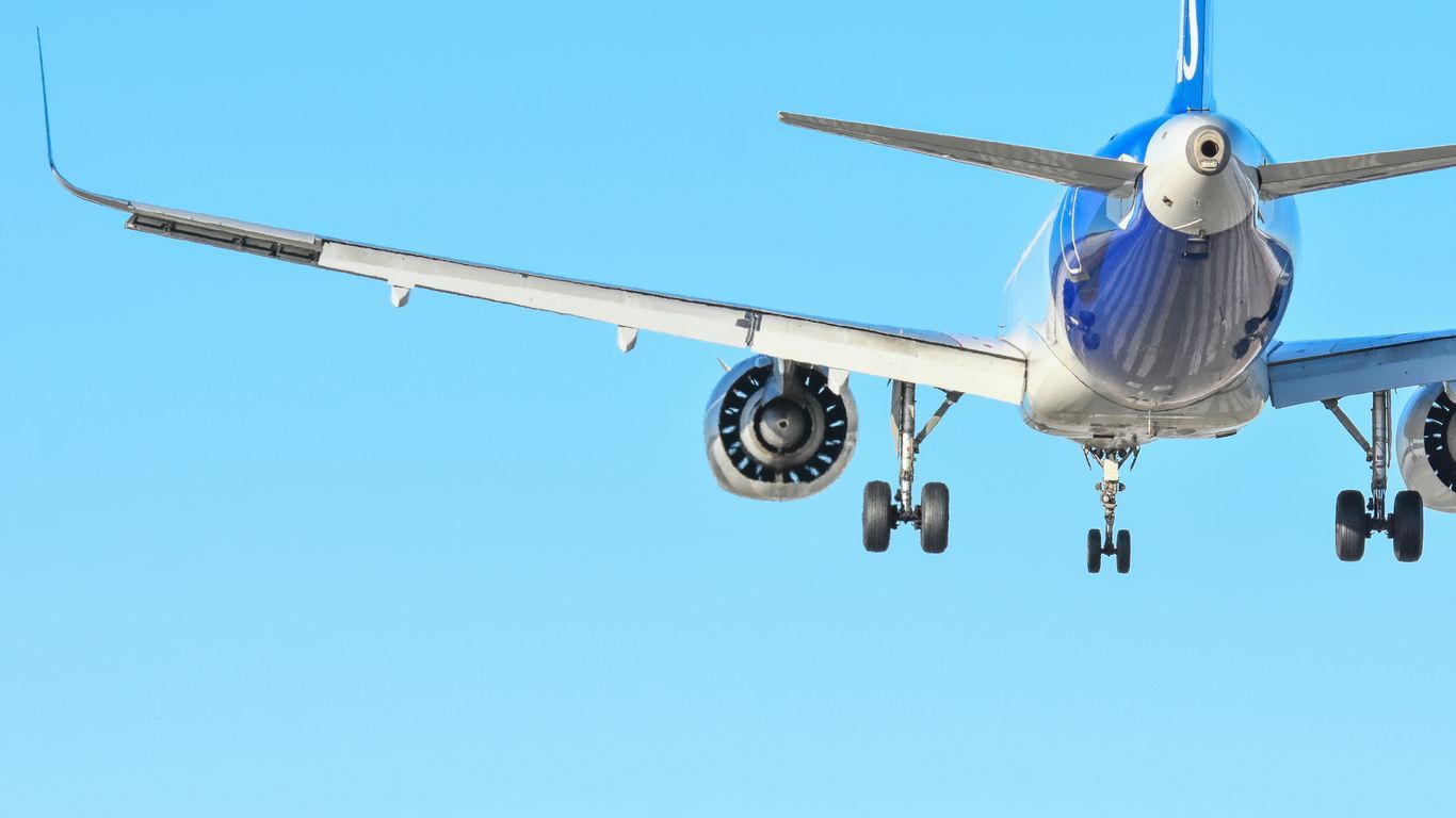 An airplane approaches for landing on a clear day.