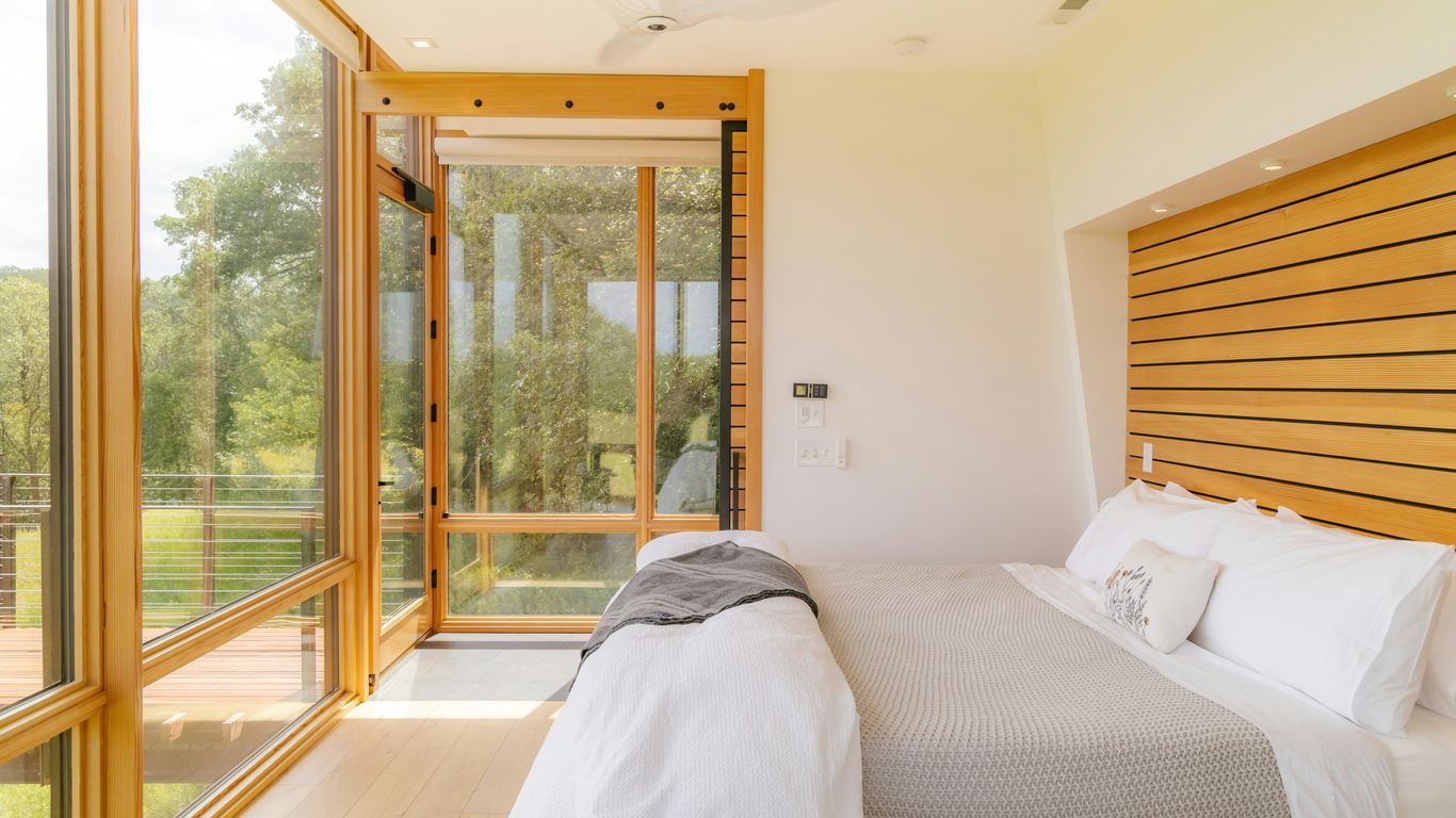 a bedroom with a bed and a large window