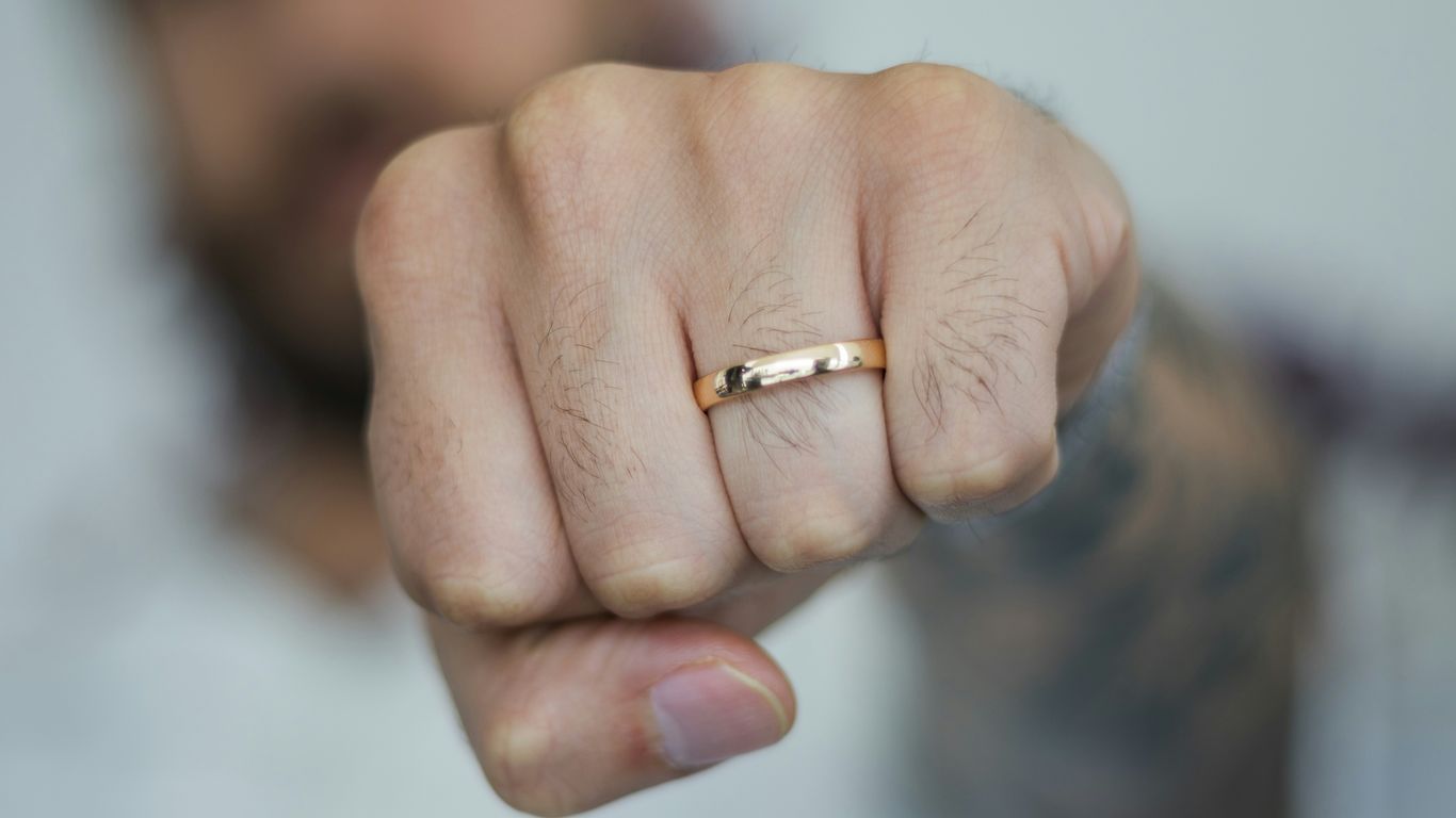 A man pointing at the camera with a ring on his finger