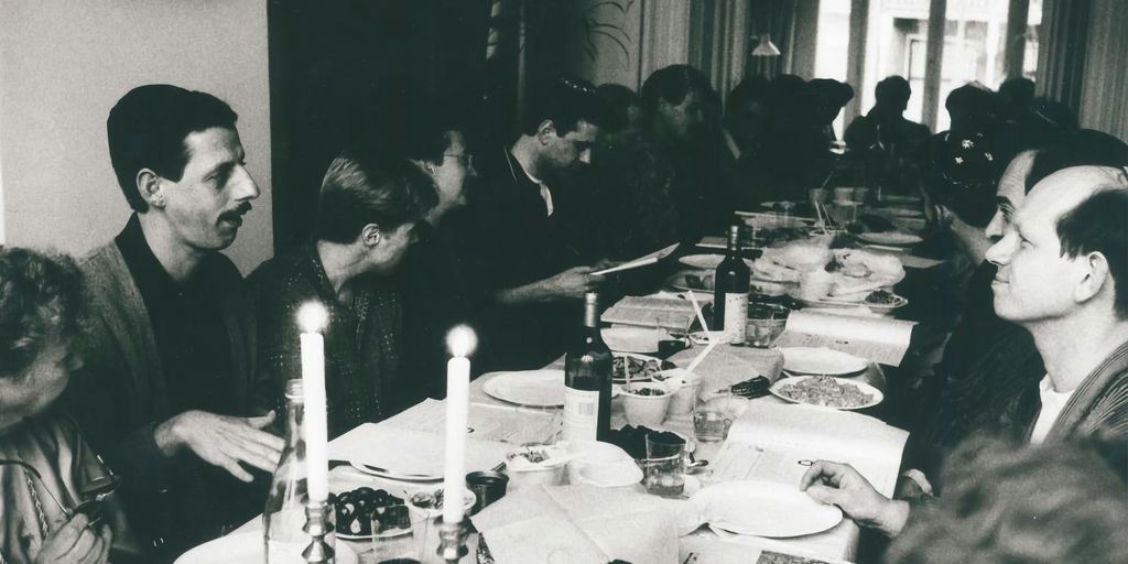 a group of people sitting around a table with food and drinks