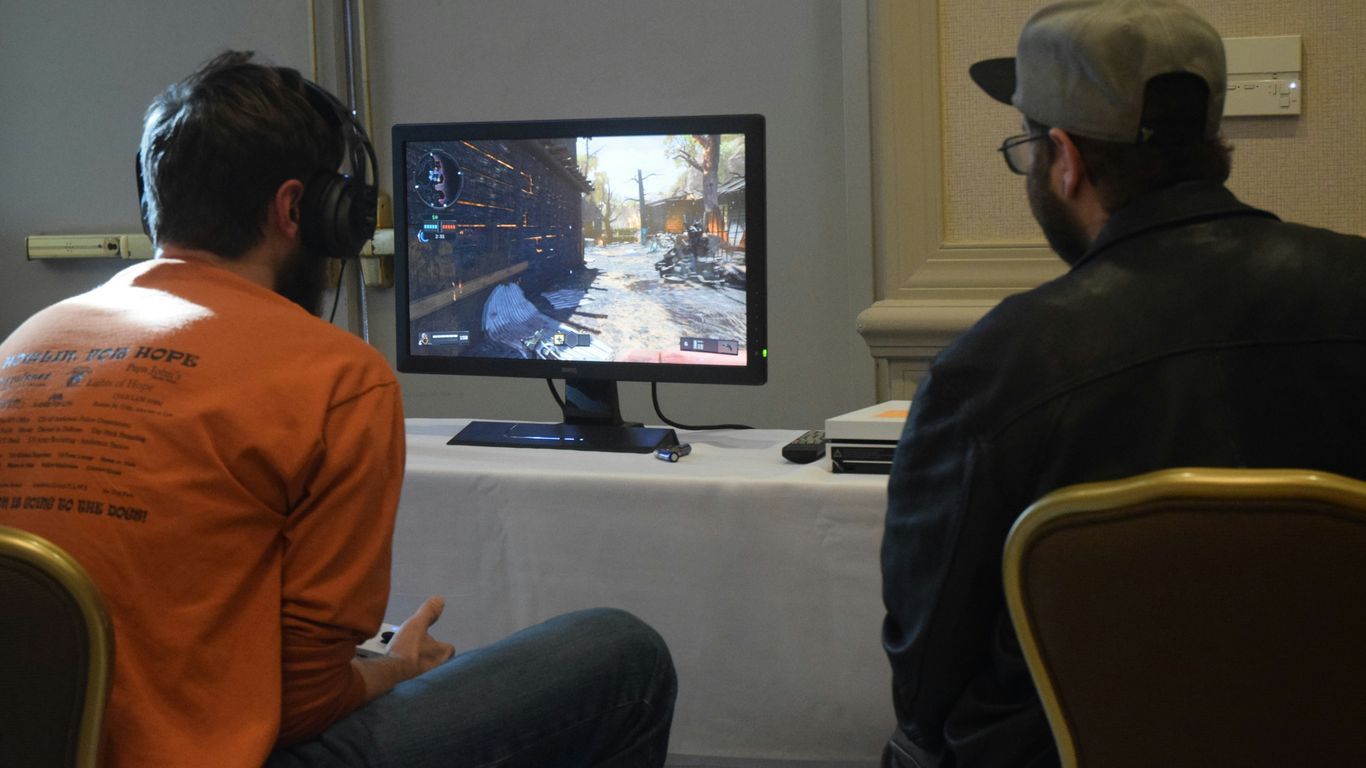 two men playing games facing monitor