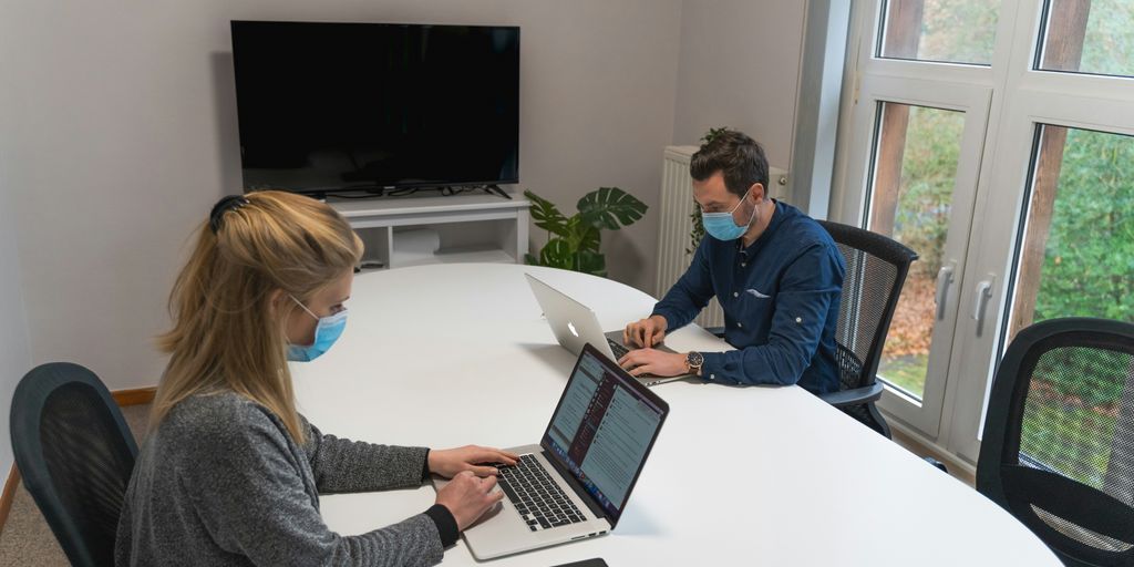 woman in gray sweater using macbook pro