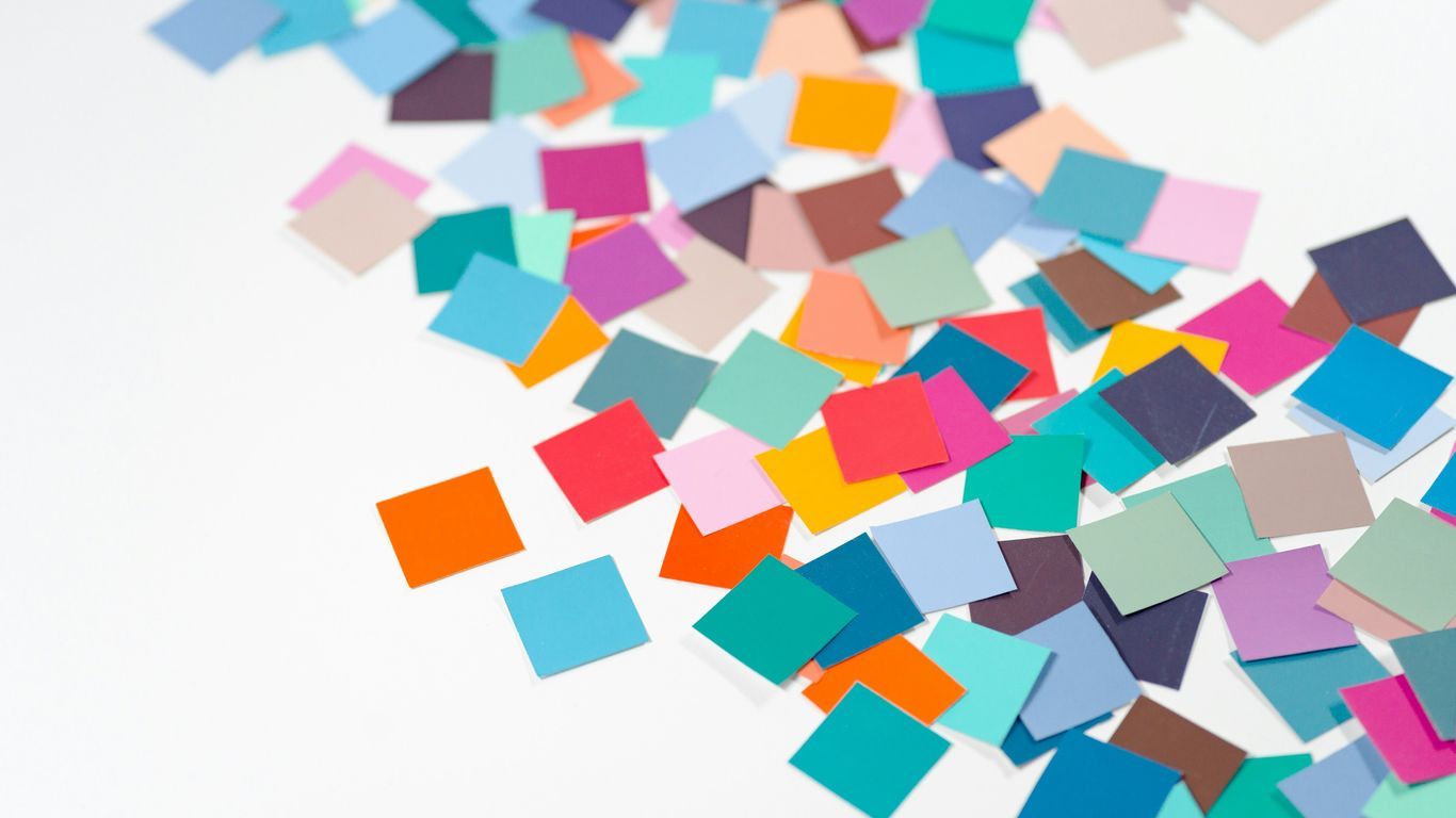 a pile of multicolored confetti sitting on top of a white table