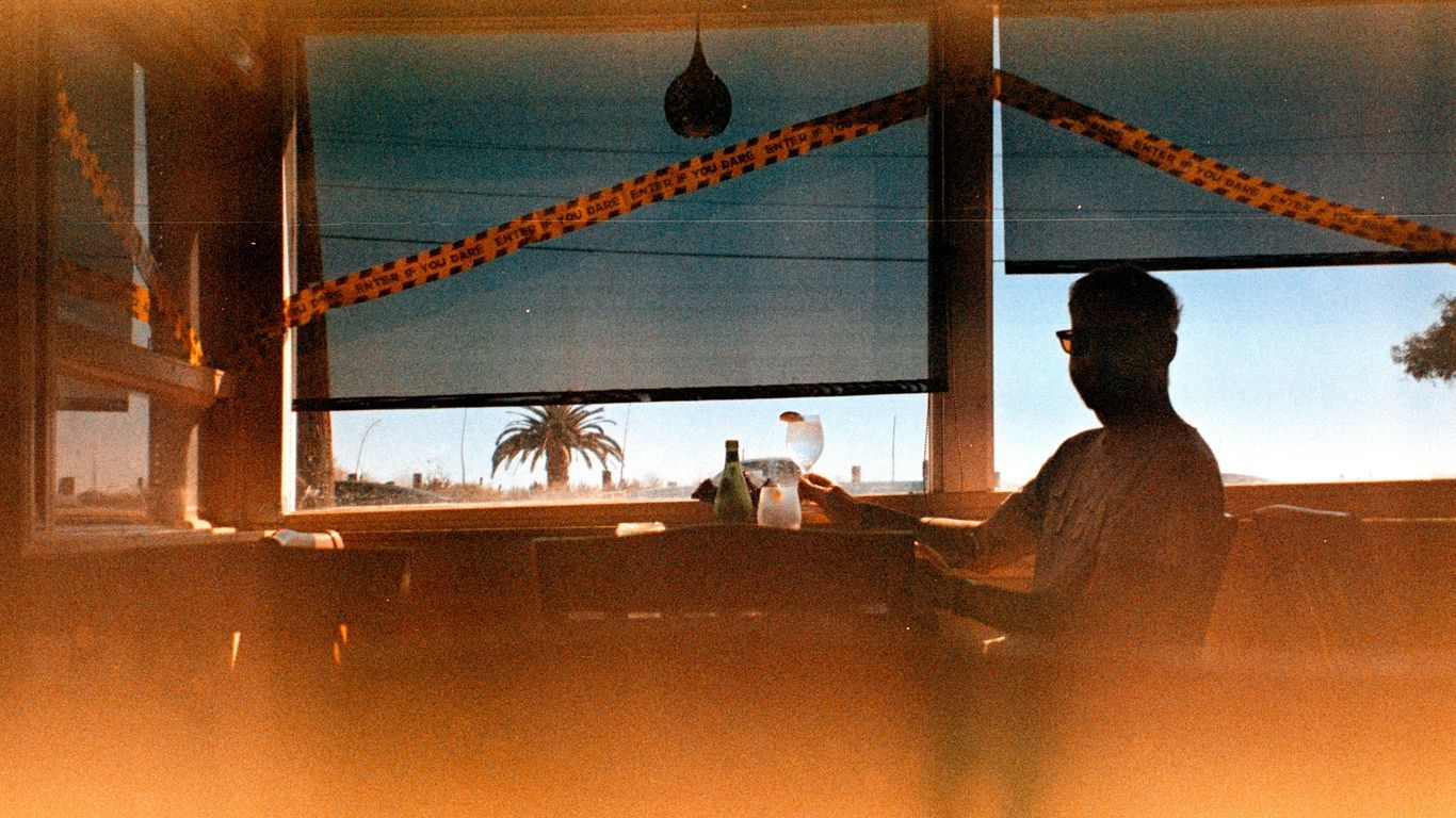 A man sitting at a table in front of a window