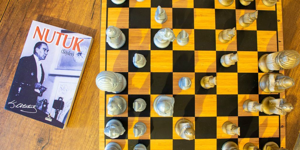 A chess board and a book on a wooden floor