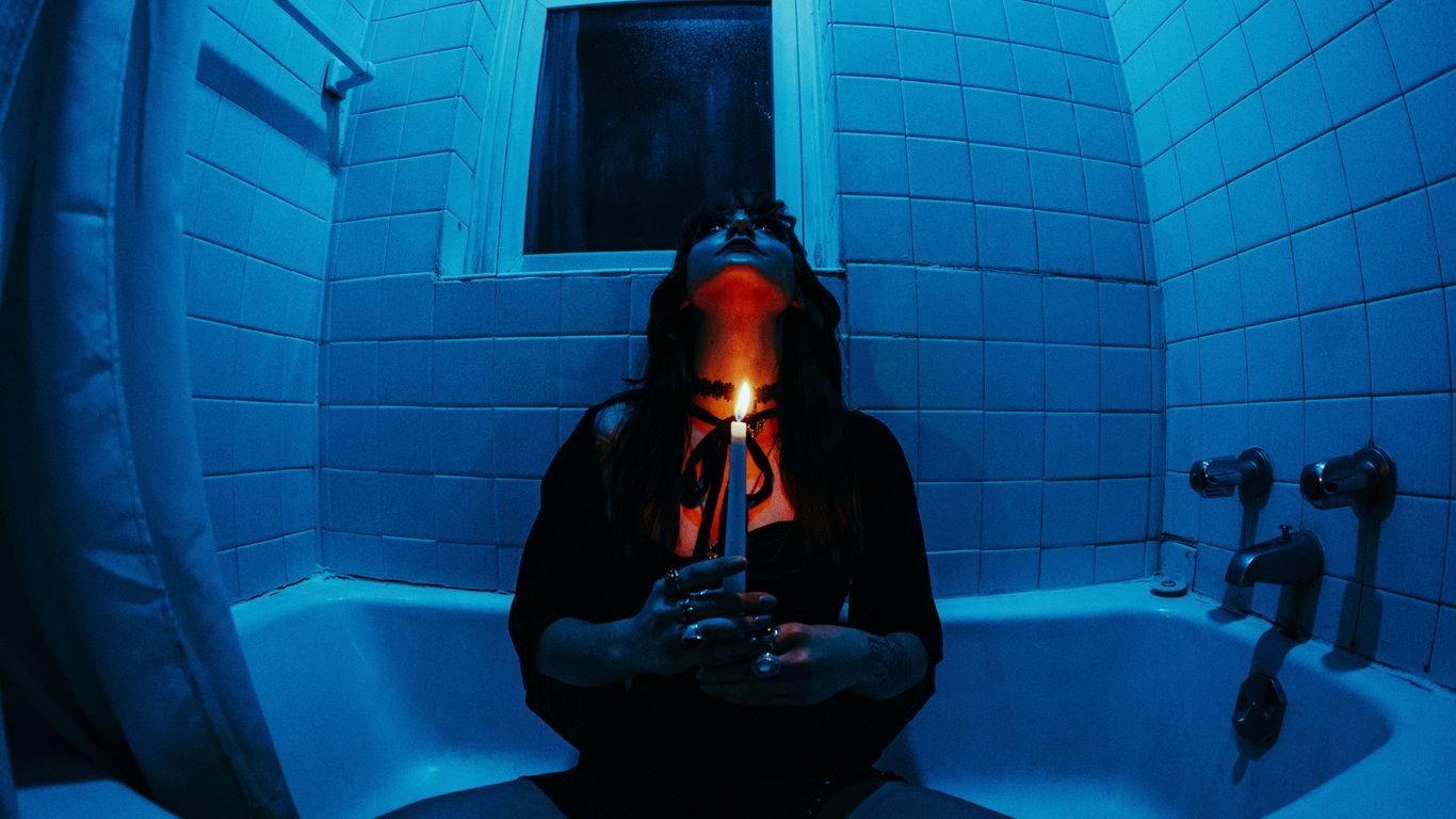 a woman sitting in a bathtub holding a cell phone