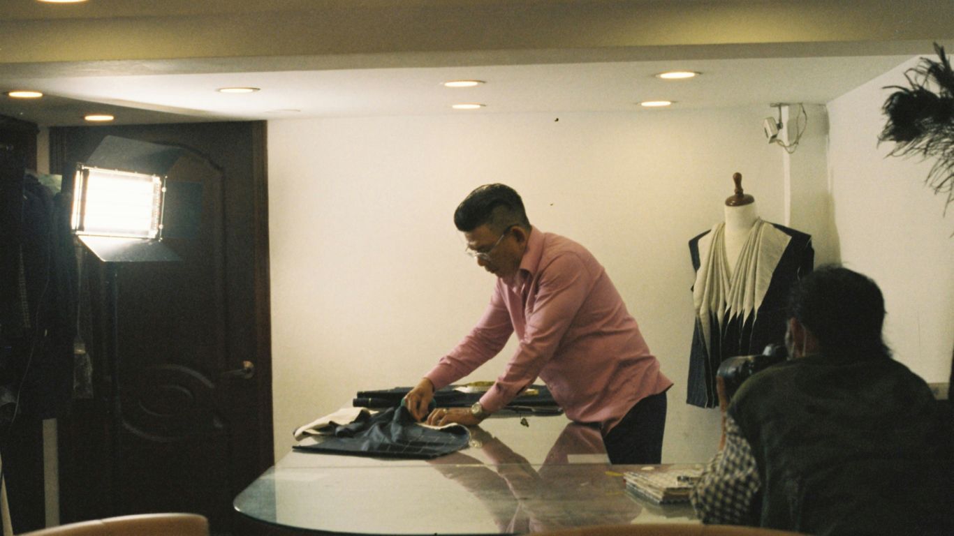a man ironing clothes on a table in a room