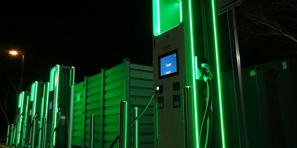 a row of green gas pumps at night