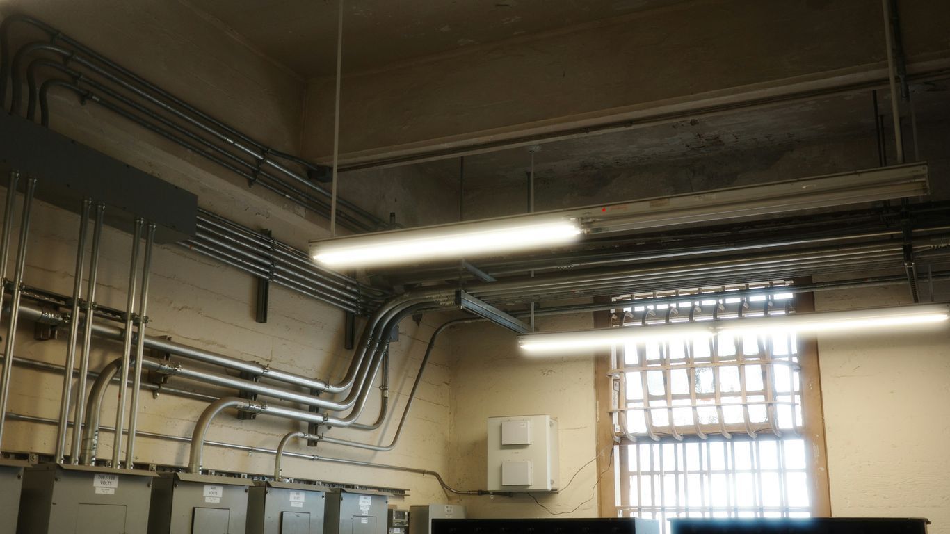 The room shows electrical wiring and lighting fixtures.