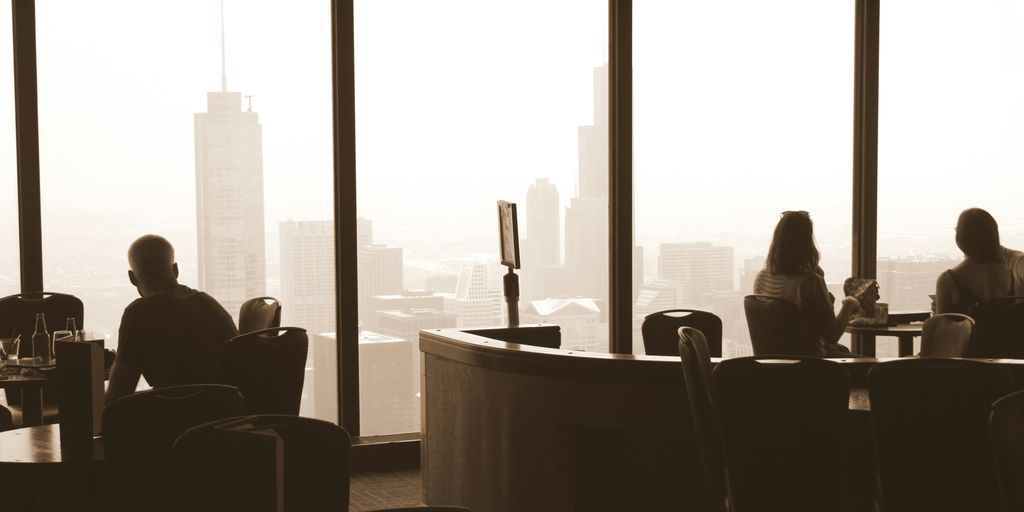 a group of people sitting at a table in front of a window
