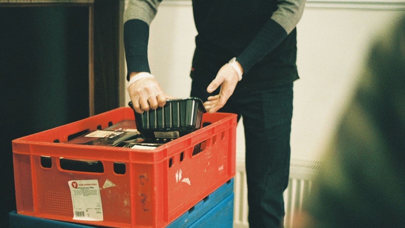 a man is putting something in a plastic container