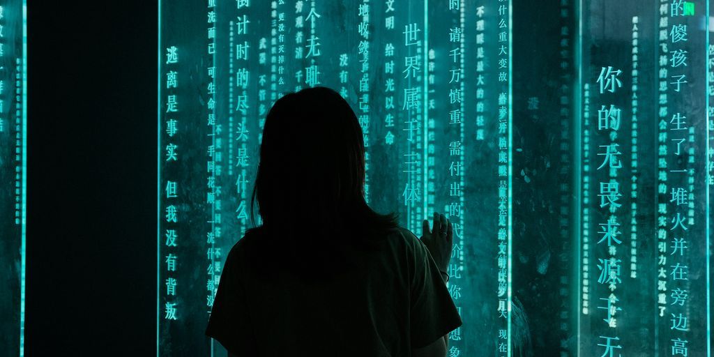 silhouette of woman standing in front of blue light
