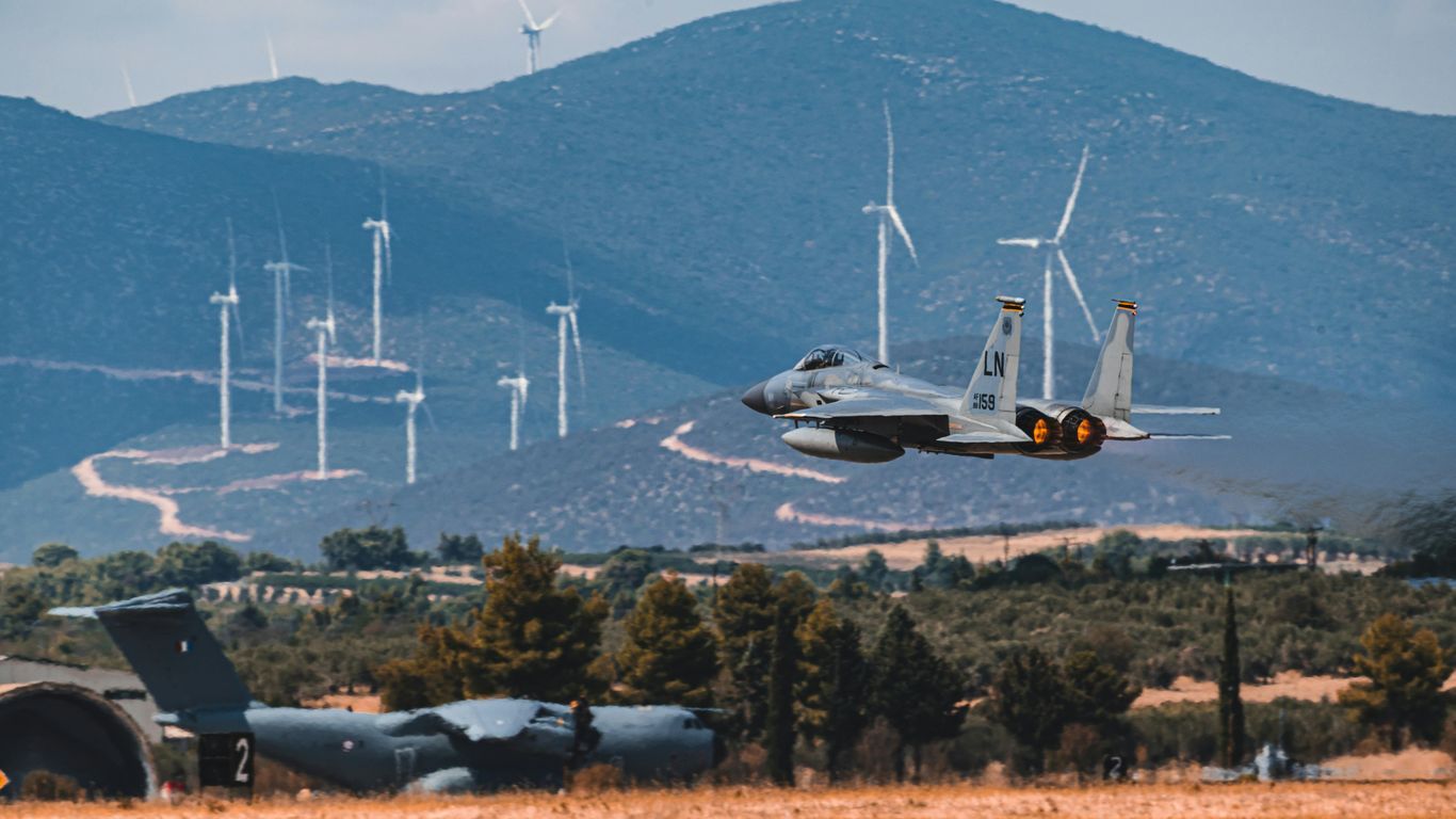 white and black fighter plane flying over green trees during daytime