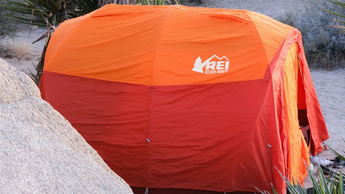 an orange and red tent sitting on top of a rock