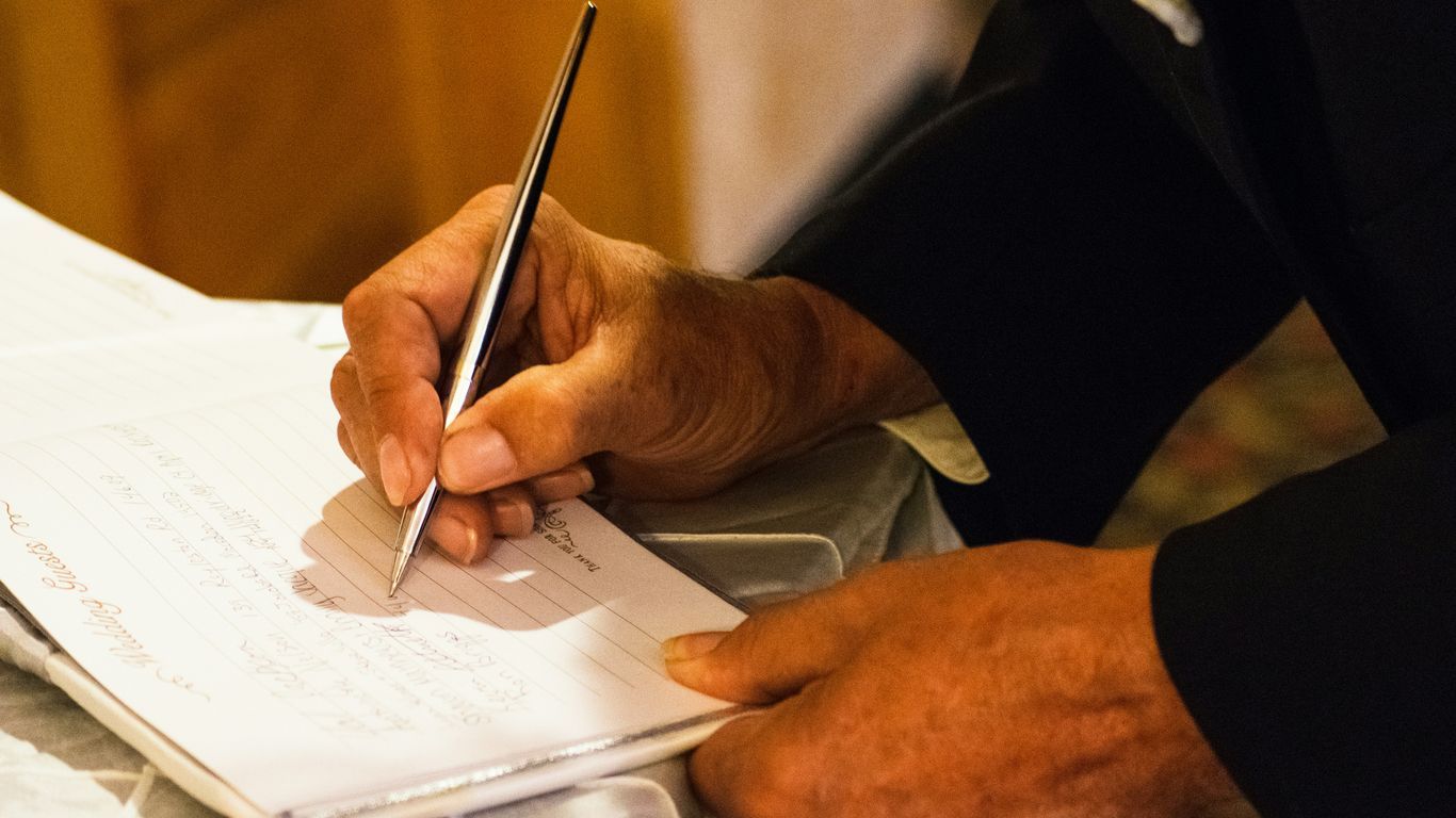 person writing on notebook