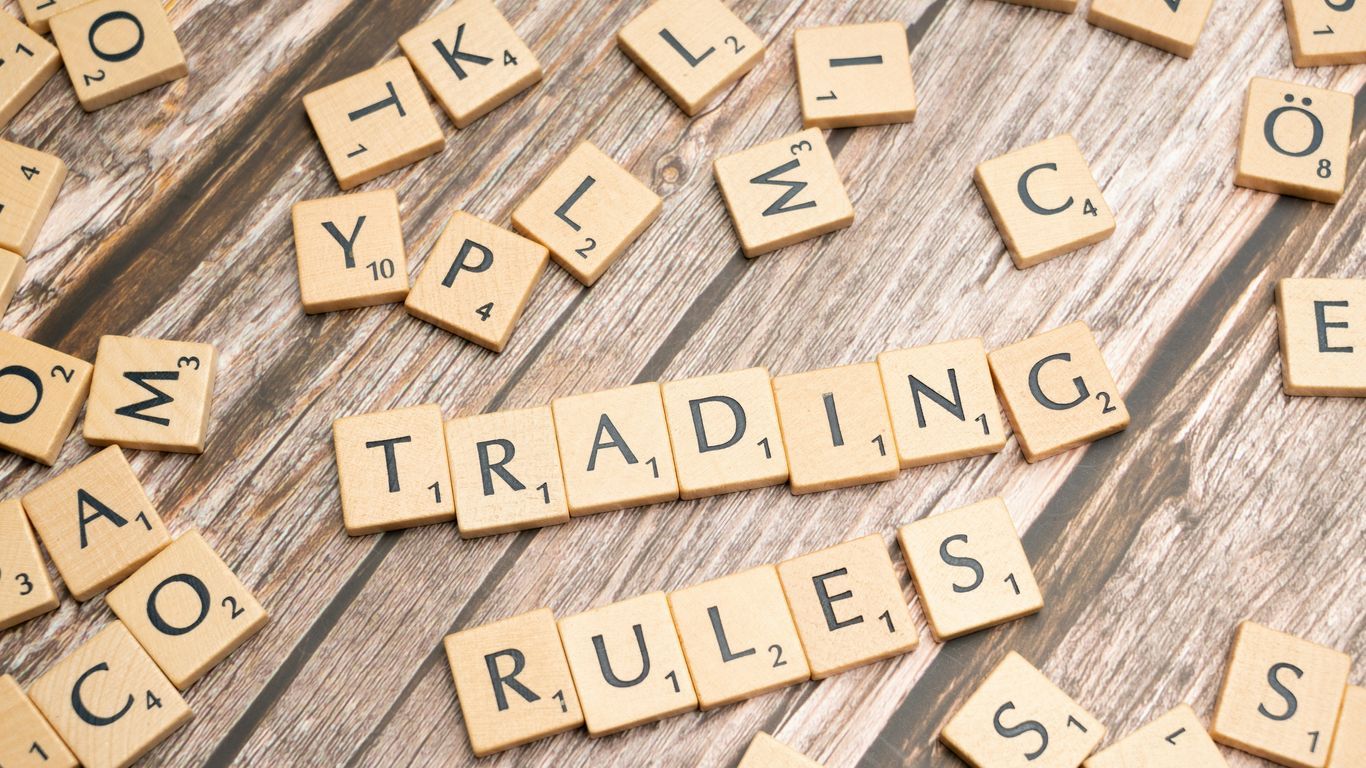 scrabble tiles spelling trading rules on a wooden table