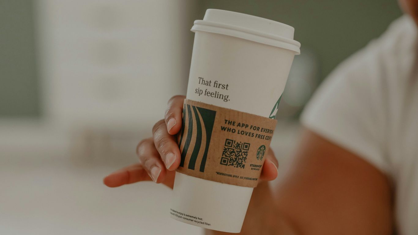 a person holding a cup of coffee in their hand