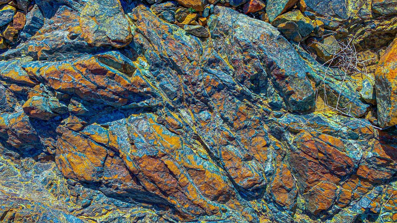 a close up of a rock with yellow and blue colors