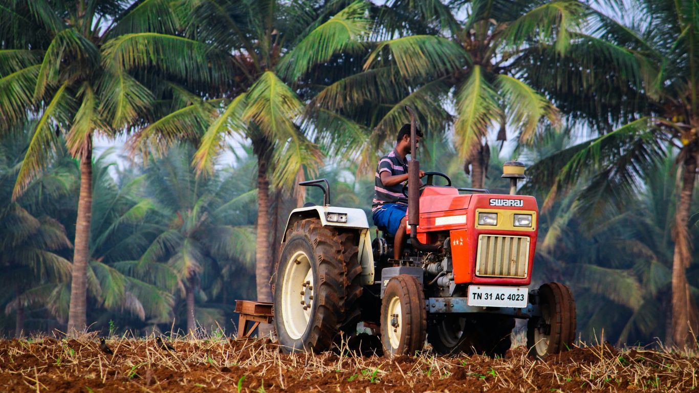 blue and red tractor on brown grass field during daytime