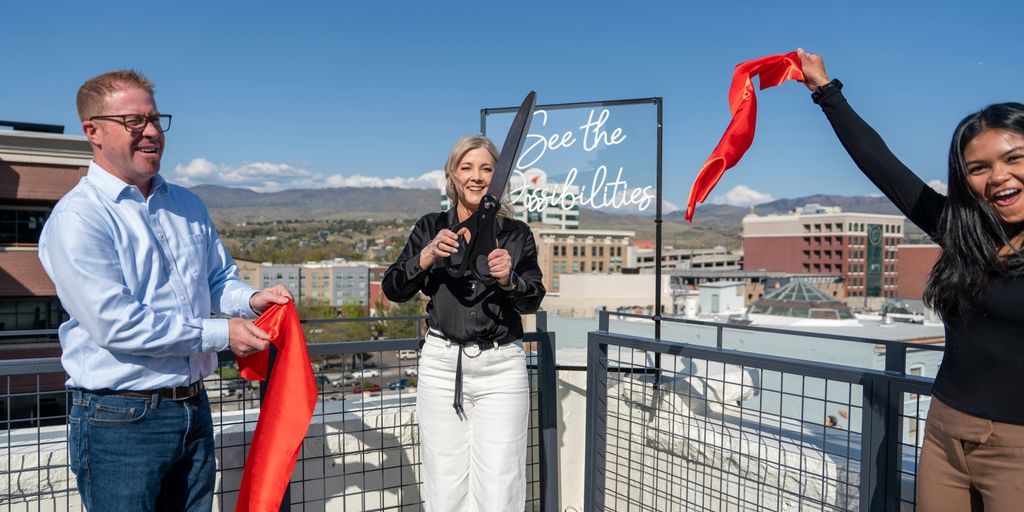 People are cutting a ribbon on a rooftop.