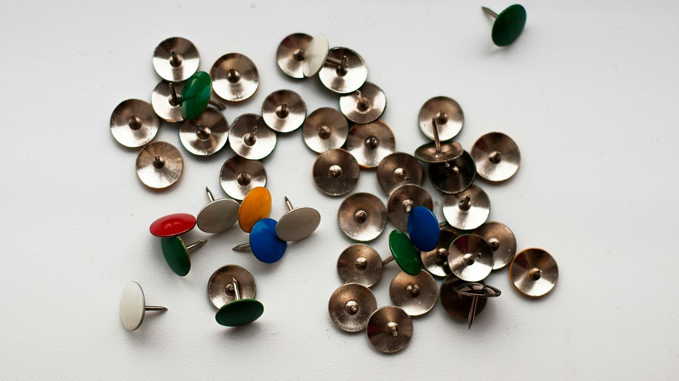 a pile of metal buttons sitting on top of a white table